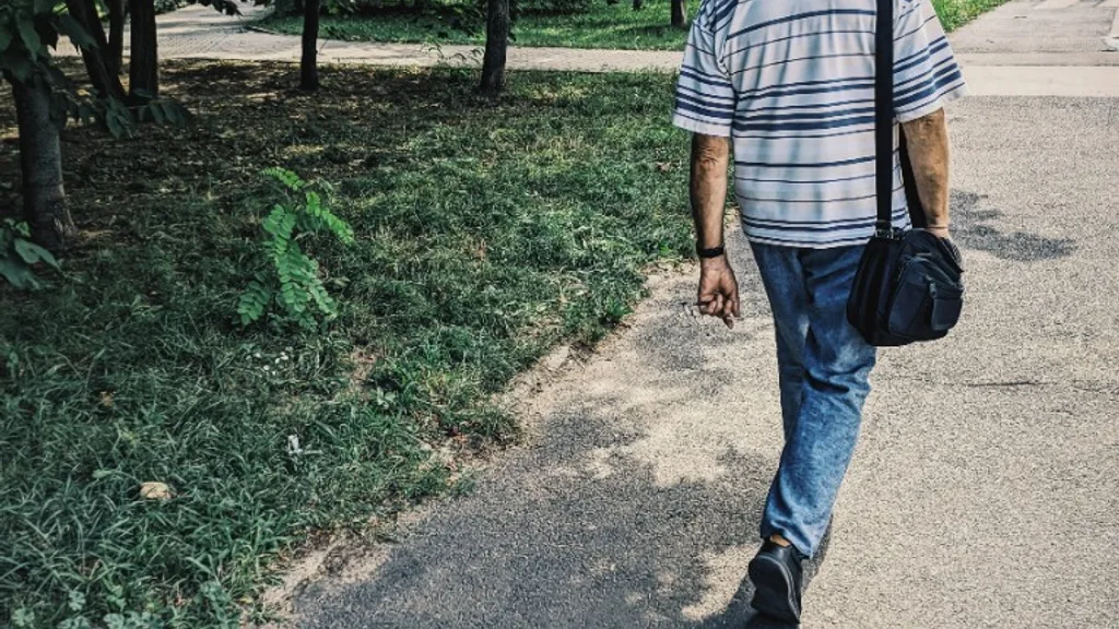 Homme âgé marchant seul dans un parc