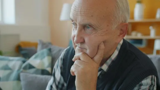 Homme âgé pensif dans un salon